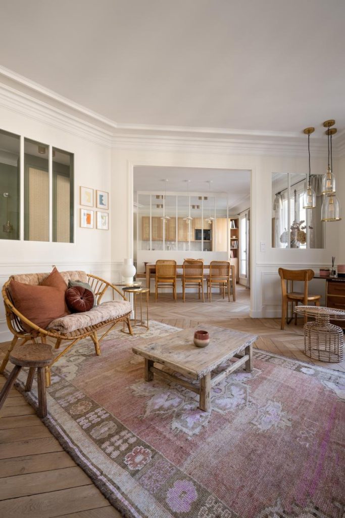 appartement parisien avec parquet chevron et cuisine ouverte avec verrière donnant sur la salle à manger puis le salon